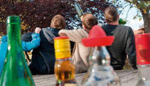 Young people with their backs turned at a botellón.