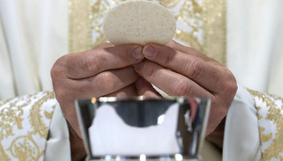 Sacerdote consagra en la Misa.