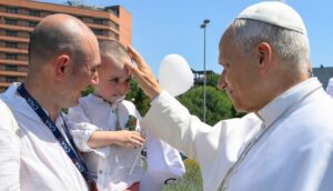 Il Papa benedice un bambino a Pavia.